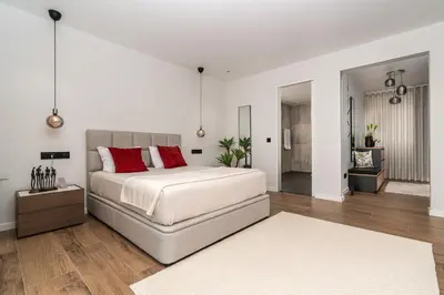 a bedroom with a bed and a chair and a window at Belo Horizonte in Estreito da Calheta