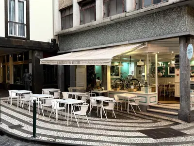 a group of tables and chairs in front of a building at Apartment Minorca 2 in Funchal