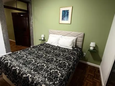a bedroom with a bed with a black and white comforter at Apartment Minorca 2 in Funchal