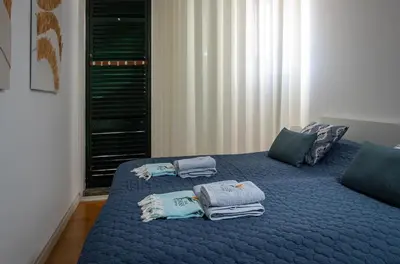 a bedroom with a blue bed with towels on it at Lido Oasis Funchal in Funchal
