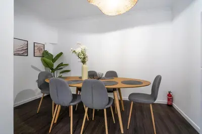 a dining room with a wooden table and chairs at Lido Oasis Funchal in Funchal