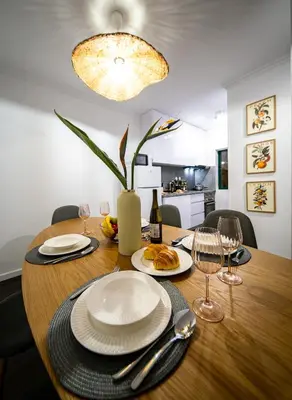 a dining room table with plates and wine glasses at Lido Oasis Funchal in Funchal