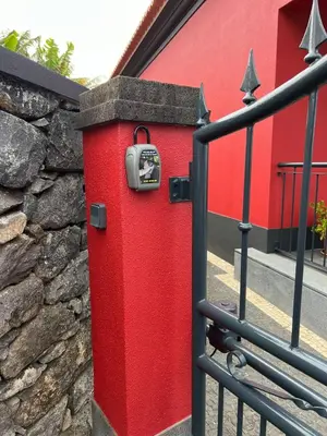 a red post box next to a stone wall at Studio Refúgio in Ponta do Sol