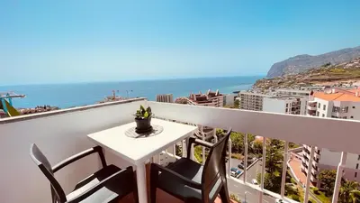 a balcony with a table and chairs and the ocean at Madeira Ocean Suite 1 in Funchal