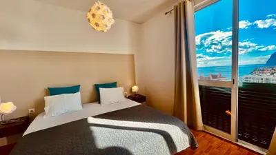 a bedroom with a bed with a large window at Madeira Ocean Suite 1 in Funchal