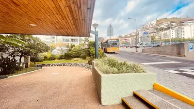 a yellow bus is parked at a bus stop at Madeira Ocean Suite 1 in Funchal