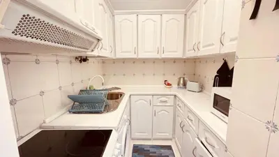 a kitchen with white cabinets and a sink at Madeira 1003 in Funchal
