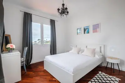 a white bedroom with a white bed and a window at Flory House by ALMA Holiday Rentals in Funchal