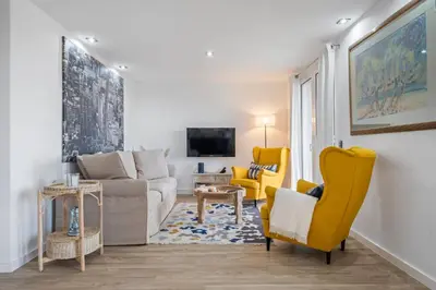 a living room with yellow chairs and a couch at Flory House by ALMA Holiday Rentals in Funchal