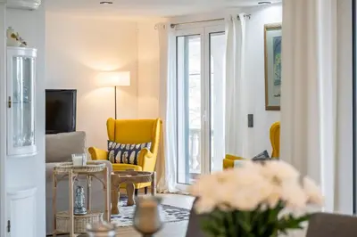 a living room with yellow chairs and a television at Flory House by ALMA Holiday Rentals in Funchal
