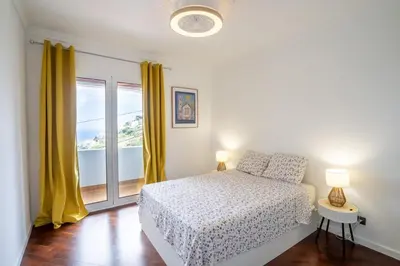 a white bedroom with a bed and a window at Flory House by ALMA Holiday Rentals in Funchal