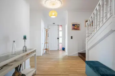 a hallway with white walls and a staircase with a light fixture at Flory House by ALMA Holiday Rentals in Funchal