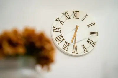 a clock with roman numerals hanging on a wall at Apartamento Brava JT in Ribeira Brava