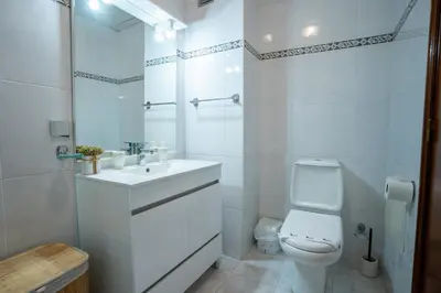 a white bathroom with a toilet and a sink at Apartamento Brava JT in Ribeira Brava