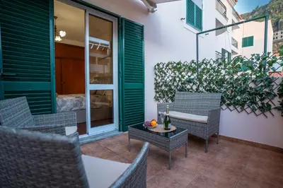 a patio with chairs and a table and a plant at Apartamento Brava JT in Ribeira Brava