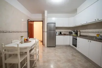 a kitchen with a table and a refrigerator at Apartamento Brava JT in Ribeira Brava