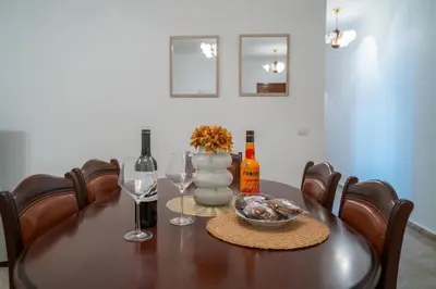 a dining room table with wine glasses and a vase at Apartamento Brava JT in Ribeira Brava