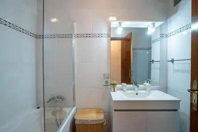 a white bathroom with a sink and a shower at Apartamento Brava JT in Ribeira Brava