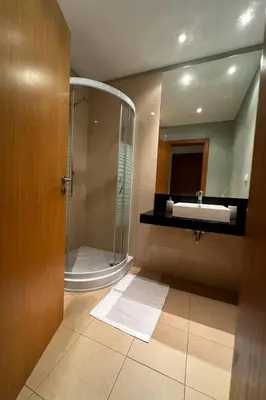 a bathroom with a shower and a sink and a mirror at Alojamiento Local - Nilia in Caniço