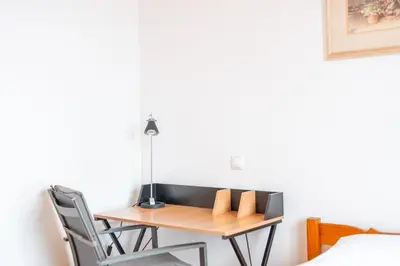 a bedroom with a bed and a chair and a desk at Caniço Horizon Apartment by Amazing Madeira in Caniço