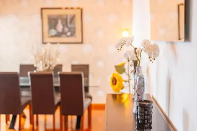a vase of flowers on a table in a living room at Caniço Horizon Apartment by Amazing Madeira in Caniço