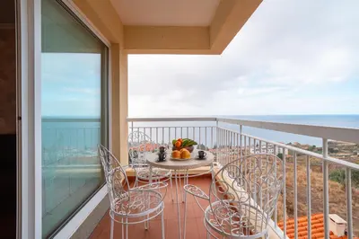 a dining room with a glass table and chairs at Caniço Horizon Apartment by Amazing Madeira in Caniço