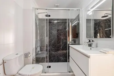 a bathroom with a shower and a toilet and a sink at Our Nest by ALMA Holiday Rentals in Caniço