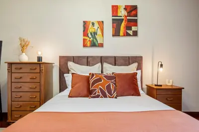 a bedroom with a bed with pillows and paintings on the wall at Our Nest by ALMA Holiday Rentals in Caniço