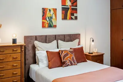 a bedroom with a bed with a wooden headboard and pillows at Our Nest by ALMA Holiday Rentals in Caniço