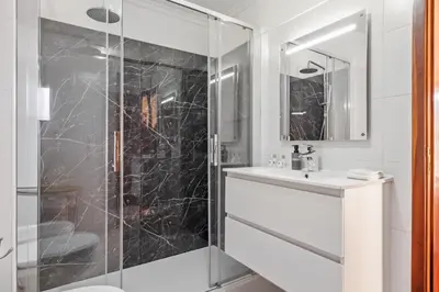 a bathroom with a glass shower and a sink at Our Nest by ALMA Holiday Rentals in Caniço