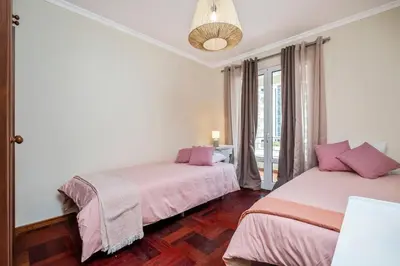 a bedroom with two beds with pink sheets at Nata7 Apartment in Funchal