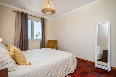 a bedroom with a white bed and a mirror at Nata7 Apartment in Funchal