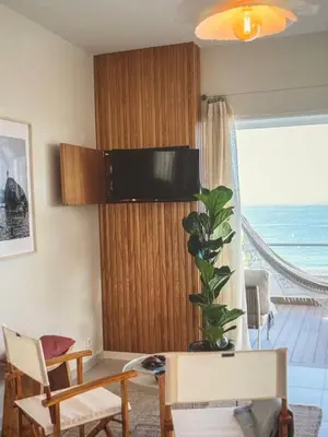 a living room with a table and a plant at Sunny seaside stay in Vila Baleira
