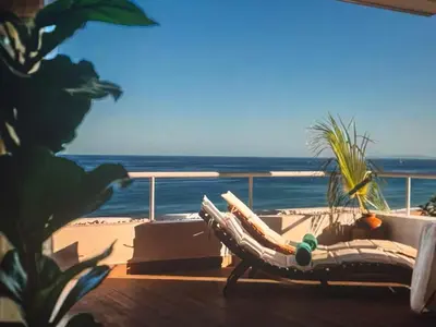 a hammock on a balcony overlooking the beach at Sunny seaside stay in Vila Baleira