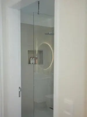 a bathroom with a glass shower with a toilet at Sunny seaside stay in Vila Baleira