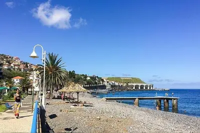 a beach with a pier and people on the water at Faty`s Place by Susys Holidays in Santa Cruz