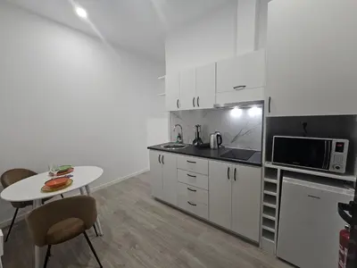 a kitchen with white cabinets and a table and a microwave at Faty`s Place by Susys Holidays in Santa Cruz