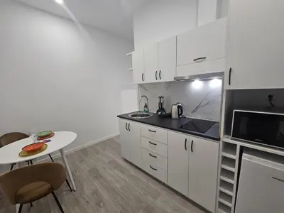 a kitchen with white cabinets and a table and a microwave at Faty`s Place by Susys Holidays in Santa Cruz