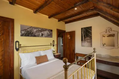 a bedroom with a bed and a staircase at Antiga Fábrica da Manteiga by An Island Apart in Arco da Calheta