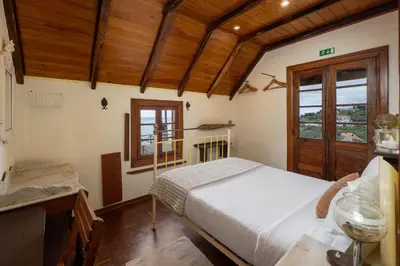 a bedroom with a bed and a wooden ceiling at Antiga Fábrica da Manteiga by An Island Apart in Arco da Calheta