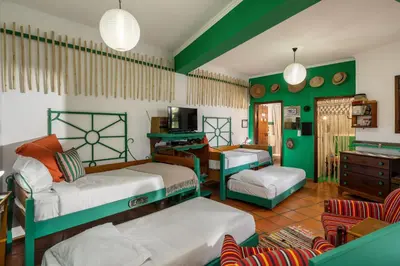 a room with two bunk beds and a kitchen at Antiga Fábrica da Manteiga by An Island Apart in Arco da Calheta