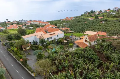 an aerial view of a town on a hill next to the ocean at Antiga Fábrica da Manteiga by An Island Apart in Arco da Calheta