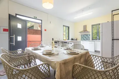 a table in a room with a television on a wall at Avo Maria House by AH in São Vicente
