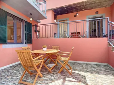 a house with a wooden table and chairs on a patio at Avo Maria House by AH in São Vicente