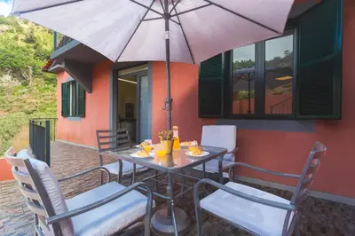 a dining room with a table and chairs and a door at Avo Maria House by AH in São Vicente