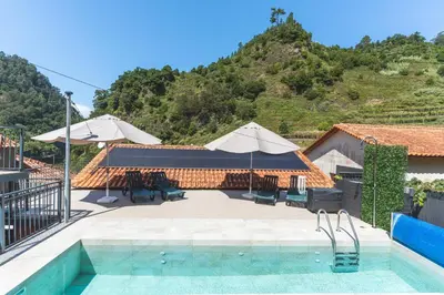 a resort with a swimming pool and a mountain at Avo Maria 2 House by AH in São Vicente