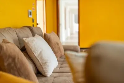 a couch with pillows on it in a living room at Vilaugusto in São Vicente