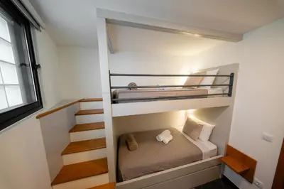 a bedroom with a bunk bed and a staircase at Rodrigues House - Private Jacuzzi in Calheta