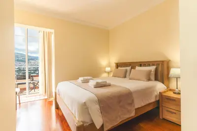 a bedroom with a bed and a large window at Santo Antonio View by Atlantic Holiday in Funchal
