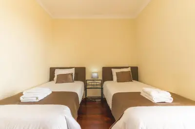 a room with two beds with white sheets at Santo Antonio View by Atlantic Holiday in Funchal